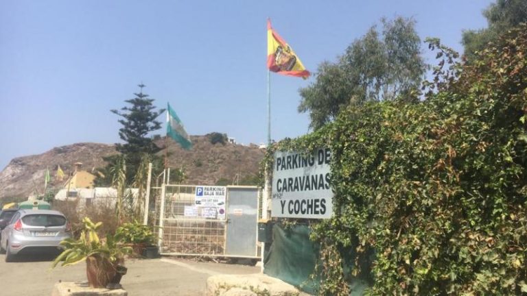 España monarquia facista: Una bandera franquista recibe los turistas en un parking de playa en Málaga