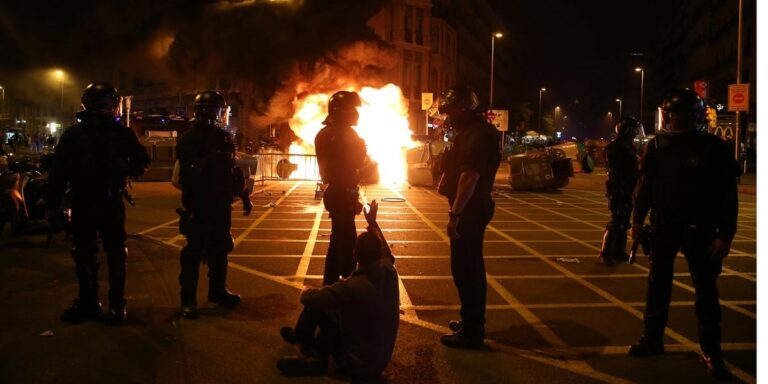 [Fotonoticia]  Imagen viral de una pareja dándose un beso en los disturbios del 1-O de trasfondo